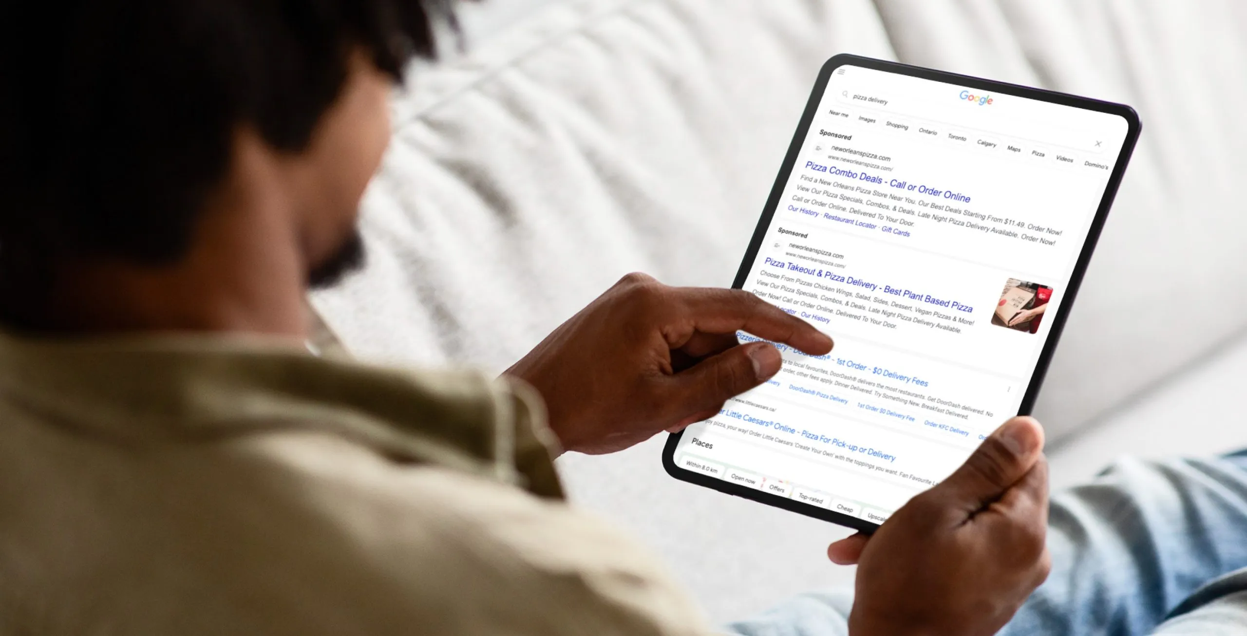a man googling pizza delivery on an ipad