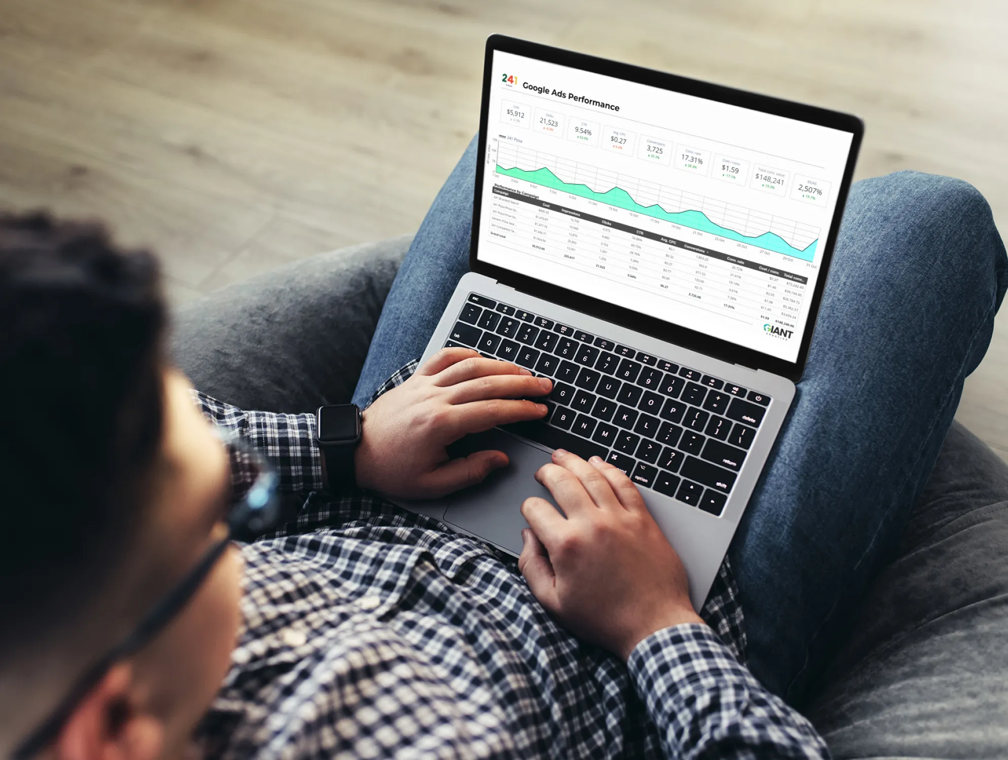 a man sitting on a chair on his laptop looking a data and analytics for his google ads performance